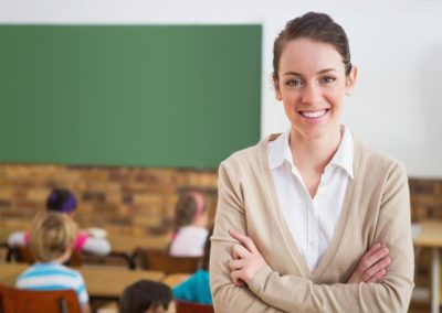 bigstock-pretty-teacher-smiling-at-came-69887626